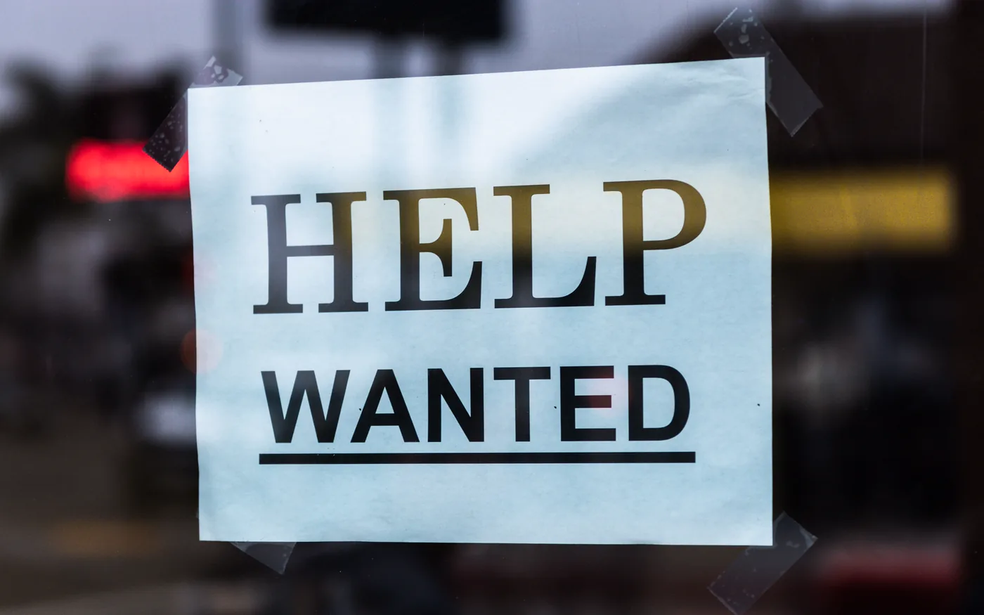 Une affiche « Help Wanted » collée à l'intérieur d'une vitrine