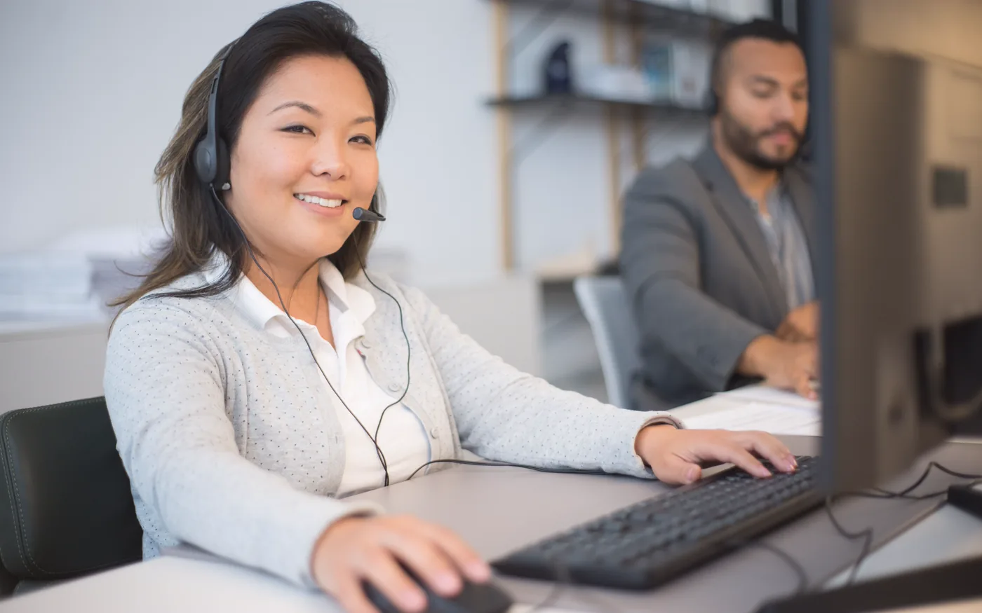 A support advisor wearing a headset at a computer