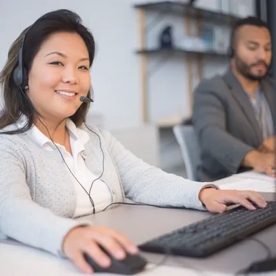 A support advisor wearing a headset at a computer