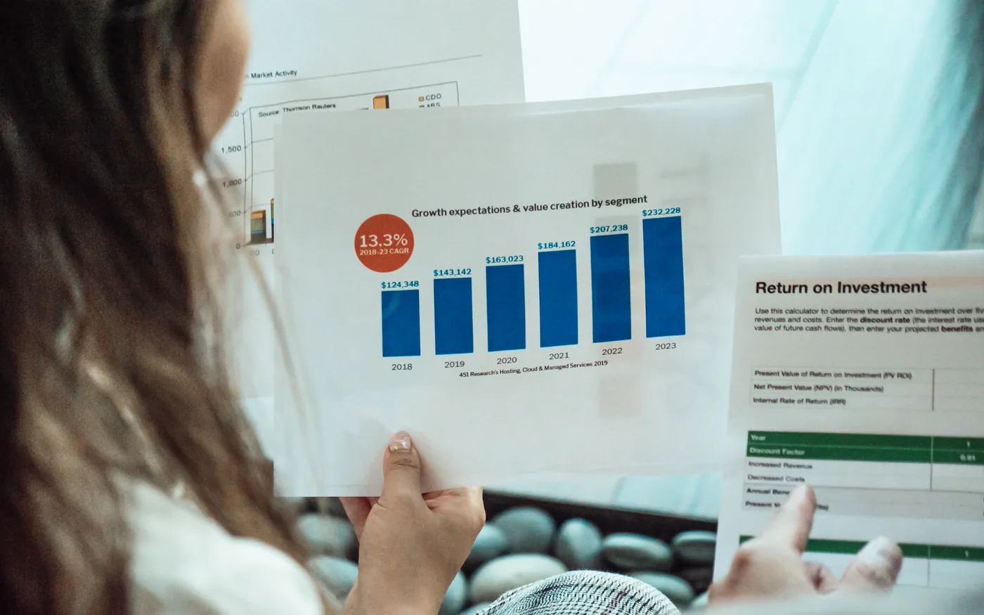 A person reviewing a printed bar chart of growth by segment