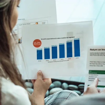 A person reviewing a printed bar chart of growth by segment