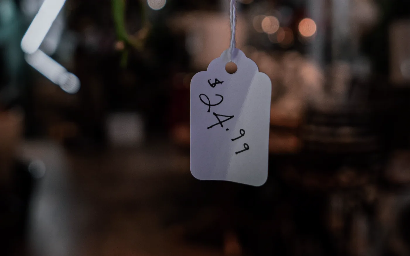 A handwritten price tag hanging in a dimly lit shop