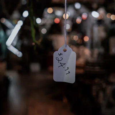 A handwritten price tag hanging in a dimly lit shop