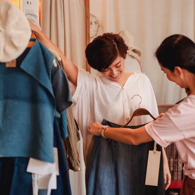 A shop assistant showing a garment on a hanger to a customer