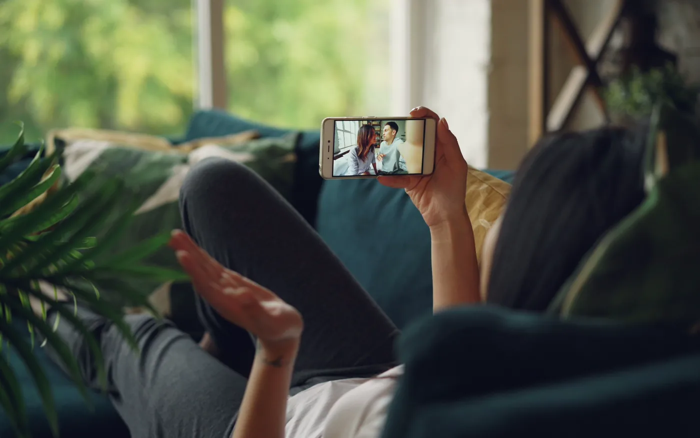 Someone on a sofa taking a video call on a phone