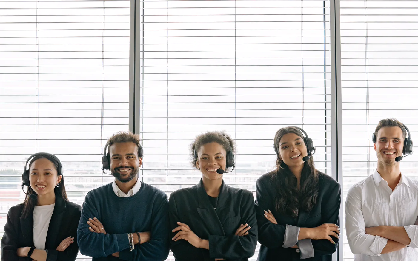 A support team wearing headsets, standing together in an office