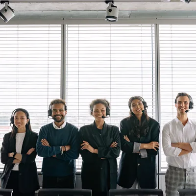 A support team wearing headsets, standing together in an office